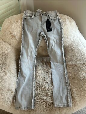 NWT Evolution in Design jeans feature distressed detailing and raw-edge cutouts.